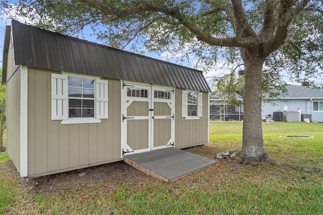 view of outdoor structure featuring a yard and central AC unit