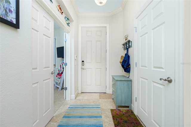 entryway with crown molding and light tile patterned floors