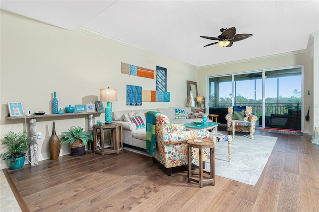 living room featuring hardwood / wood-style floors, ceiling fan, and crown molding