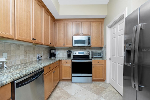 kitchen featuring backsplash, light stone countertops, and appliances with stainless steel finishes