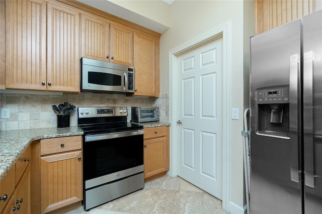 kitchen featuring light stone countertops, appliances with stainless steel finishes, decorative backsplash, and light brown cabinetry