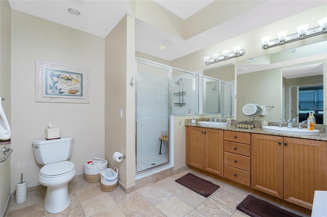 bathroom featuring vanity, toilet, and a shower with door