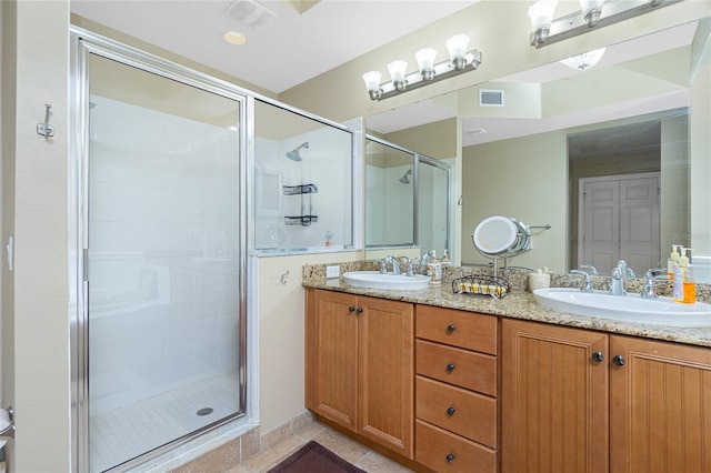 bathroom with tile patterned floors, vanity, and an enclosed shower