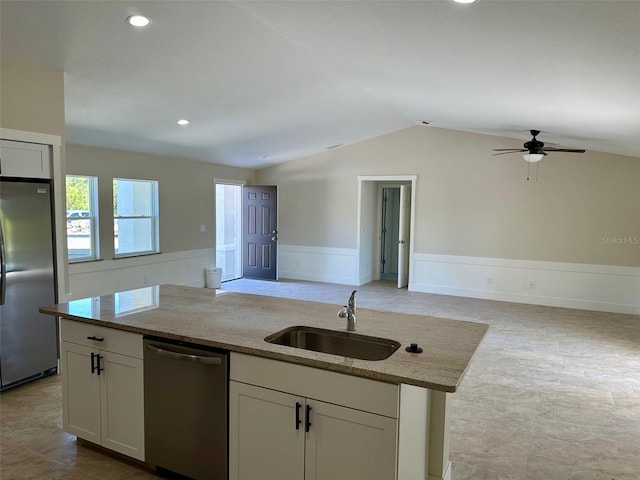 kitchen featuring a kitchen island with sink, stainless steel appliances, light stone countertops, sink, and white cabinetry