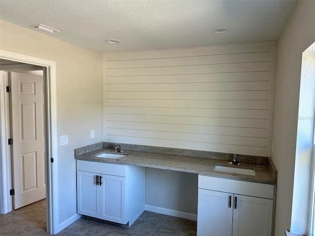 interior space with a textured ceiling and vanity