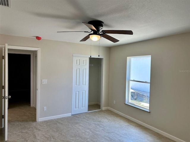 unfurnished bedroom with ceiling fan, a closet, and a textured ceiling