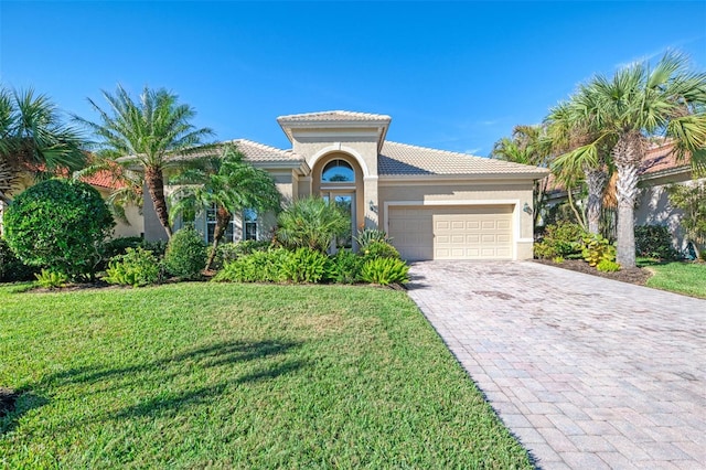 mediterranean / spanish-style house featuring a front lawn and a garage