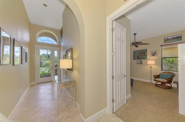 entrance foyer with ceiling fan and light colored carpet