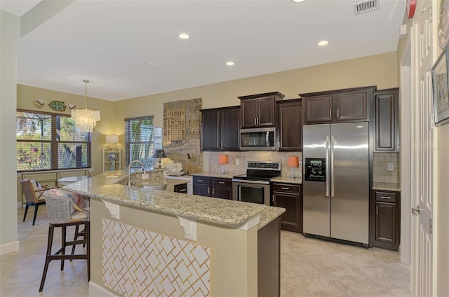 kitchen with a large island, a breakfast bar, decorative backsplash, and stainless steel appliances