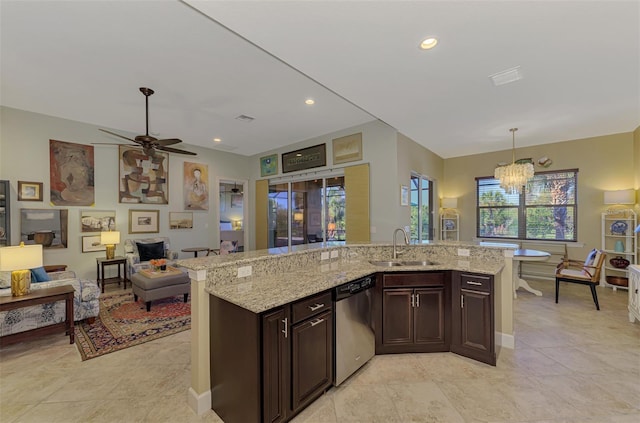 kitchen with ceiling fan with notable chandelier, sink, stainless steel dishwasher, decorative light fixtures, and light stone counters