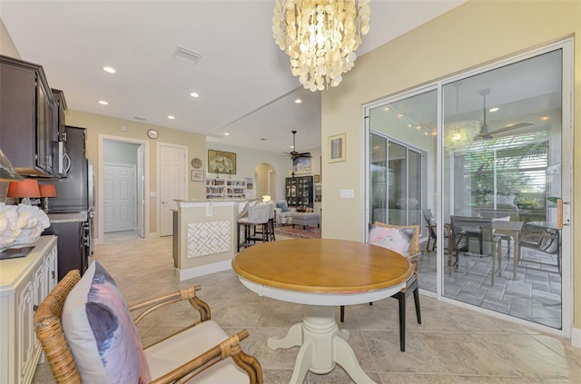 dining space with ceiling fan with notable chandelier