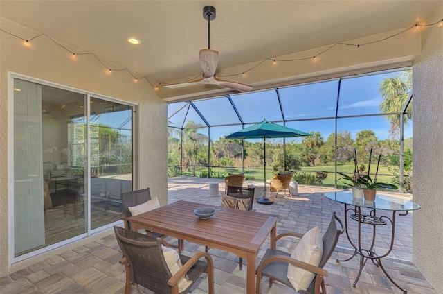 view of patio with glass enclosure and ceiling fan