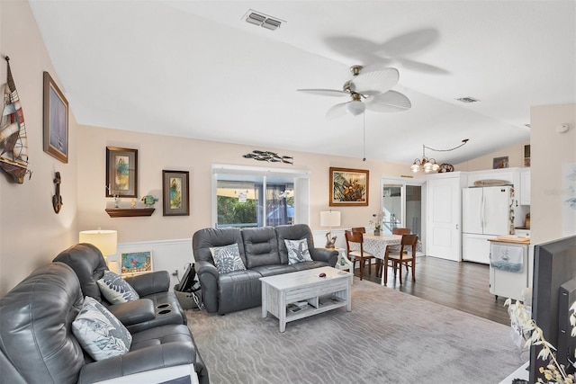 living room featuring ceiling fan with notable chandelier, dark hardwood / wood-style floors, and lofted ceiling