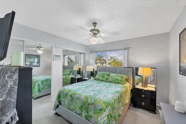 carpeted bedroom featuring ceiling fan and a textured ceiling