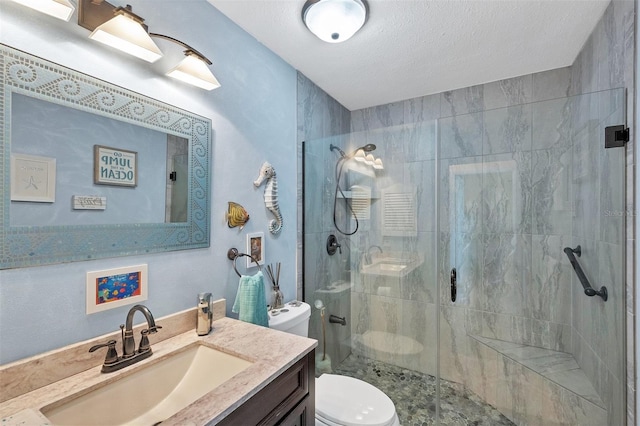 bathroom featuring vanity, a textured ceiling, toilet, and walk in shower