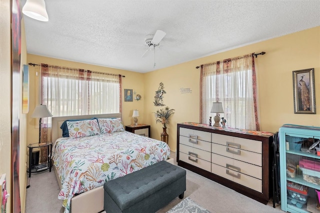 bedroom featuring light colored carpet, multiple windows, and ceiling fan