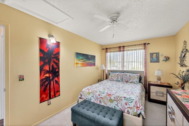 bedroom with a skylight, a textured ceiling, light colored carpet, and ceiling fan