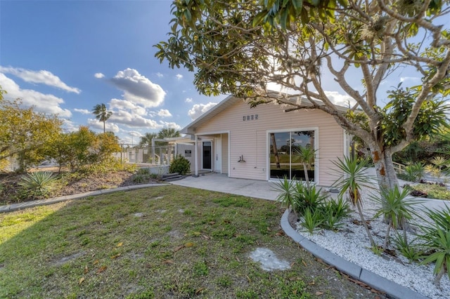 back of property featuring a lawn and a patio area