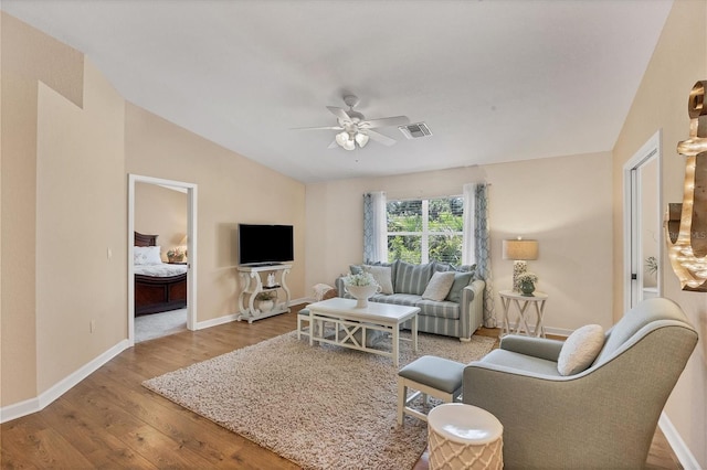 living room featuring hardwood / wood-style floors, vaulted ceiling, and ceiling fan