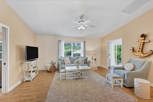 living room with vaulted ceiling, ceiling fan, and light hardwood / wood-style flooring