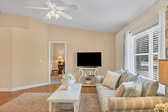 living room with vaulted ceiling, ceiling fan, and light wood-type flooring