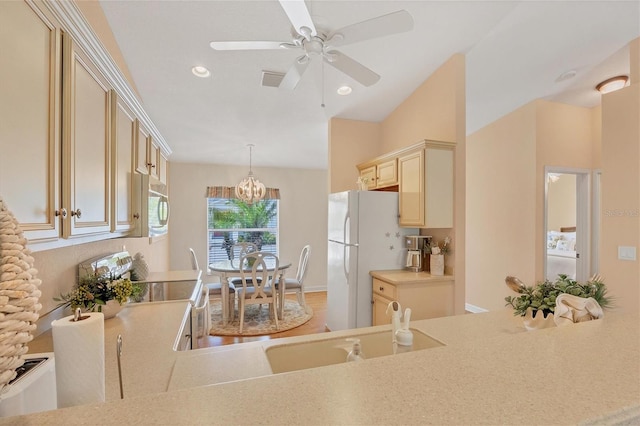 kitchen with pendant lighting, white appliances, ceiling fan, cream cabinets, and washer / dryer