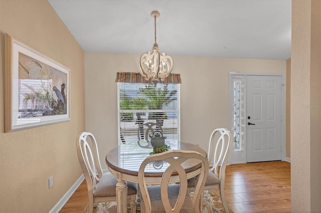 dining room with hardwood / wood-style floors and a notable chandelier