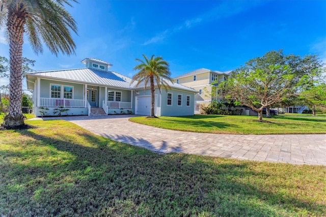 view of front of house featuring a front yard, a garage, and a porch