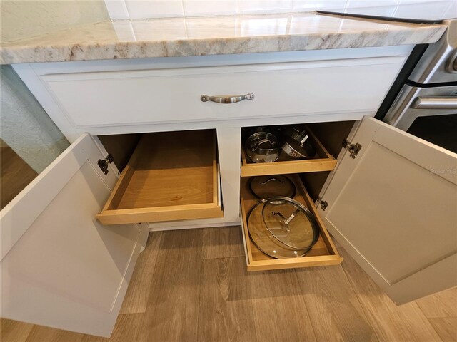 room details featuring white cabinets and light hardwood / wood-style floors