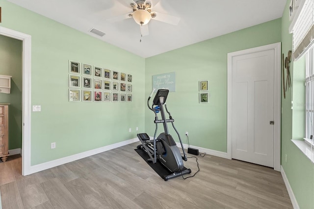 workout area with light hardwood / wood-style flooring and ceiling fan