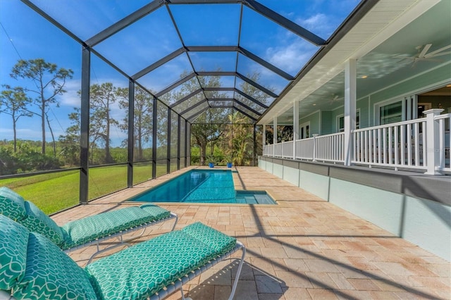 view of pool featuring a patio area, a yard, ceiling fan, and glass enclosure