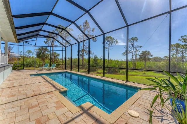 view of swimming pool with a patio area, a yard, and a lanai