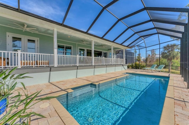 view of swimming pool featuring ceiling fan, a lanai, a patio area, and french doors