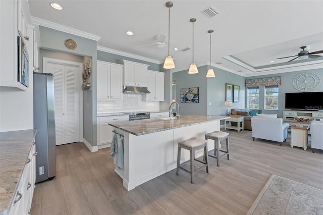 8025 Weyers Ct, Englewood, FL 34224 - kitchen with ceiling fan, stainless steel appliances, under cabinet range hood, crown molding, and open floor plan