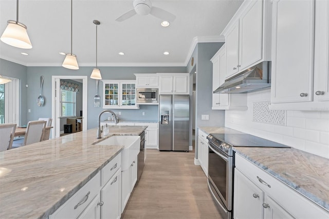 kitchen featuring appliances with stainless steel finishes, white cabinets, light stone counters, and pendant lighting