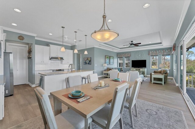 8025 Weyers Ct, Englewood, FL 34224 - dining space featuring a raised ceiling, ornamental molding, a ceiling fan, recessed lighting, and light wood-type flooring
