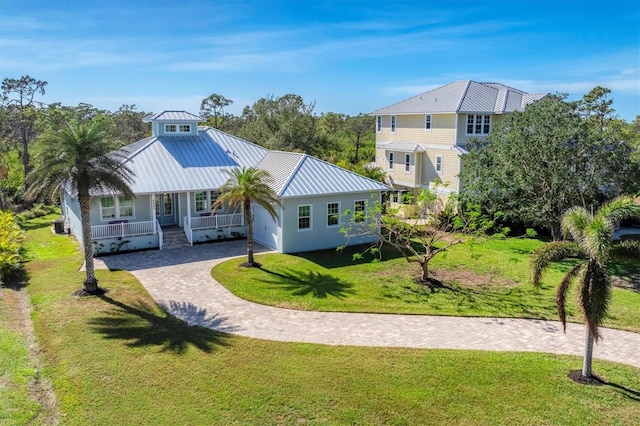 back of property with covered porch and a lawn