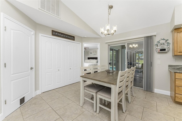 tiled dining area with a chandelier and vaulted ceiling