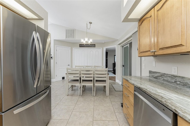 kitchen featuring pendant lighting, light stone countertops, lofted ceiling, and stainless steel appliances