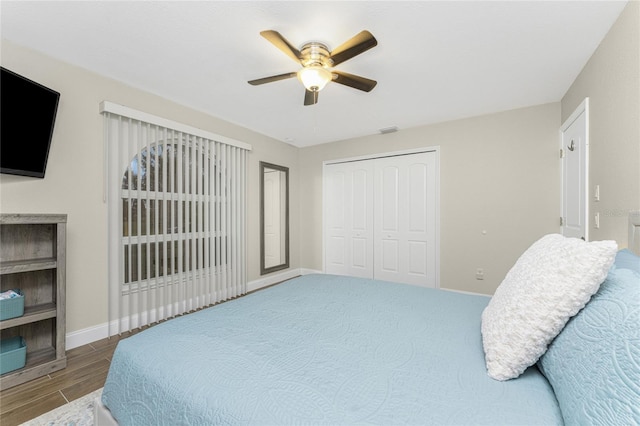 bedroom with ceiling fan, wood-type flooring, and a closet