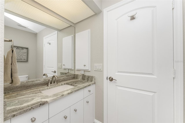 bathroom featuring vanity and toilet