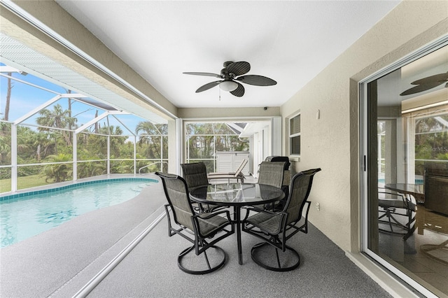 sunroom with ceiling fan, a wealth of natural light, and a swimming pool