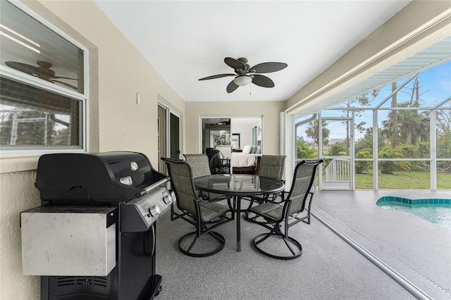 sunroom / solarium with ceiling fan and a swimming pool