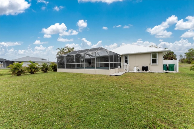 back of house with a lawn and a lanai