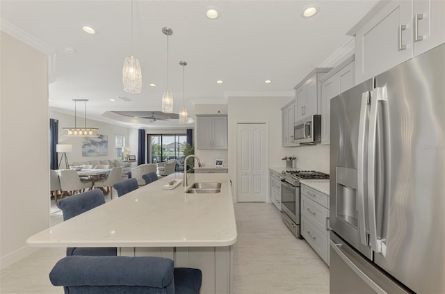 kitchen featuring pendant lighting, sink, stainless steel appliances, and a breakfast bar area