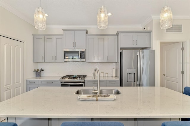 kitchen with light stone countertops, sink, stainless steel appliances, crown molding, and decorative light fixtures