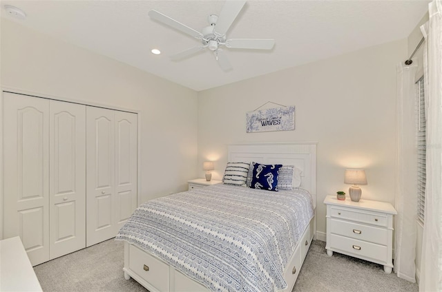 carpeted bedroom featuring ceiling fan and a closet