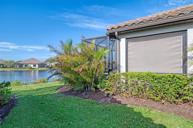 view of yard with a water view and a lanai