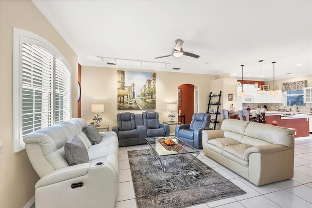 tiled living room featuring ceiling fan and track lighting