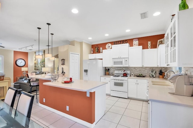 kitchen featuring a breakfast bar, white appliances, sink, a center island, and white cabinetry